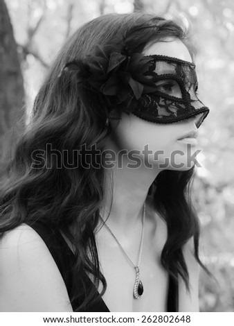Mask on young woman. Black mask lady. Brunette girl. Autumn face. Masquerade mask