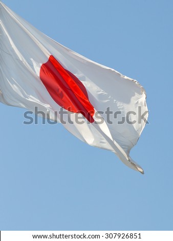 waving japanese flag over blue sky