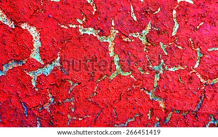 Color shriveled, peeling paint on wall - background texture. Red paint peeling off.