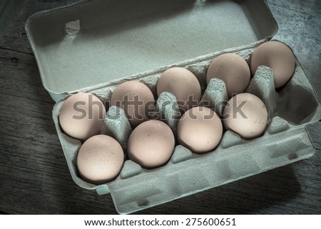 Eggs in egg carton on wood floor with retro style or rustic style