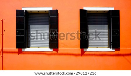 Two Windows House in Burano on orange wall building architecture, Venice, Italy