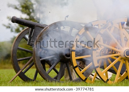 two english civil war cannon in the act of firing wading and grass coming out of the muzzle