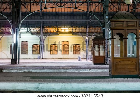 Passenger platform at night on the railway station. Train station at night.