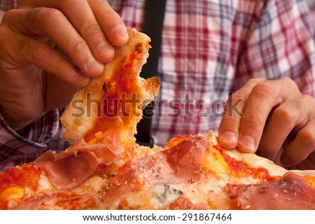Eating pizza with fingers in an italian restaurant.