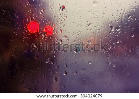 Glass of the window with raindrops and red light signal. Location Edinburgh, Scotland (picture taken from the bus).