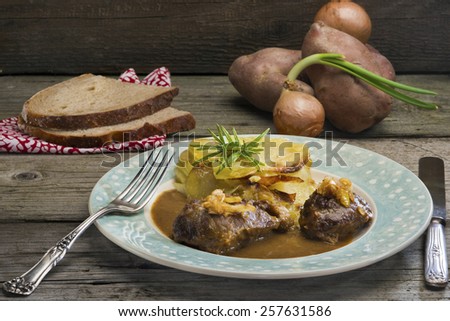 Welsh comfort food at its finest: Braised pork cheeks in gravy with cider caramelized leeks and onion cake - layers of sliced potatoes and soft onions (Welsh version of gratin dauphinois).