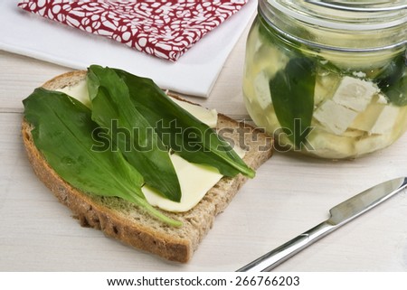 Wild garlic served on a  buttered bread and some more pickled with cheese. Wild garlic is also known as ramsons, buckrams,  broad-leaved garlic, wood garlic, bear leek or bear\'s garlic.