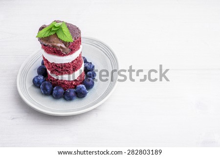 Red velvet cake with blueberries. US flag themed dessert, ideal for Independence day.\
US flag themed dessert, ideal for Independence day. Cake is iced with chocolate and decorated with balm mint.