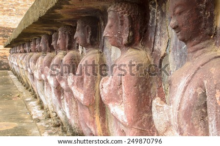 a lot of buddhism statues on base of pagoda in Sukhothai historical park