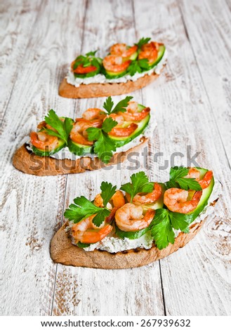 shrimp sandwich on a white wood background