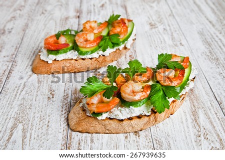 shrimp sandwich on a white wood background