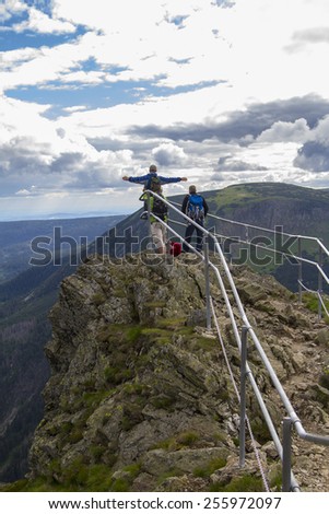 Three men on a mountain top over the precipice in the Czech Republic