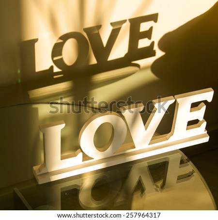 inscription love with reflection and shadow on the wall