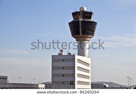 Air traffic control tower and building viewed from the ground.