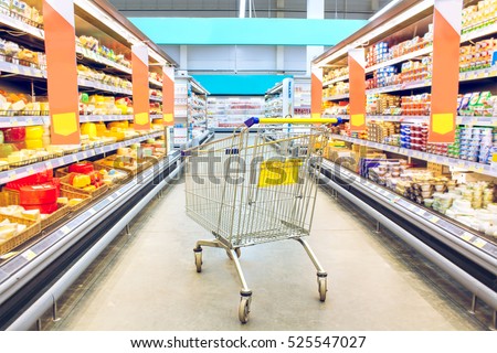 Cart at the grocery store. Supermarket interior, empty shopping trolley. Business ideas and retail trade. Advertising of food products.