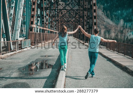 man and woman, a love story, family, grimace, funny, with reflectors on the background of the bridge, rivers, forests, mountains