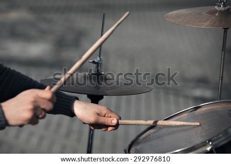 hands with drum sticks and drum