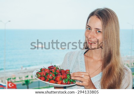 girl smiling with a big plate of strawberries