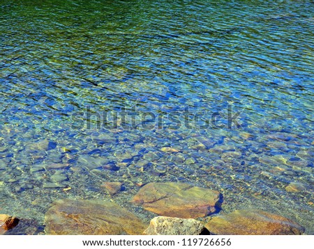 Impressionistic image of sunlight playing over the water\'s surface on Jordan Pond in Acadia, creating webs and spangles of light in an abstracted realism composition.