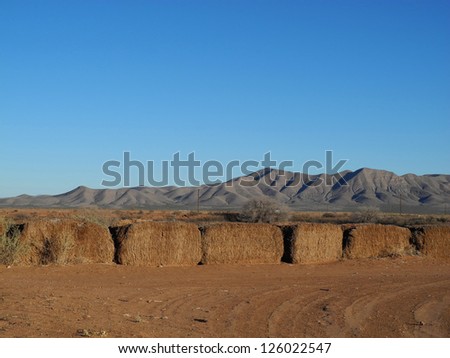 Scenic view of the Van Horn mountain range in Texas, with hay bales in the foreground.