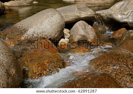 Boulders mark and gird the flow and foam of water in a pristine, scenic river in the White Mountains of New Hampshire.