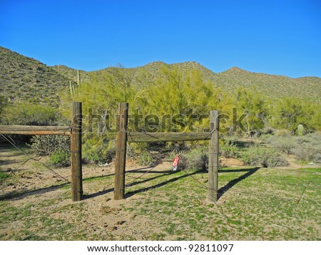 View of desert landscape and a split rail fence that evokes the \