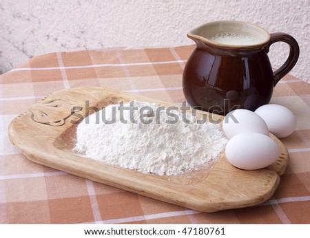 Ingredients for baking on table top: eggs, milk and flour