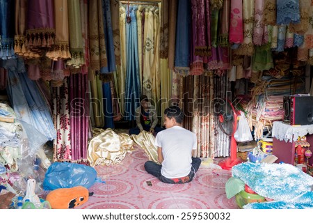 SA KAEO, THAILAND - FEBRUARY 16: Cambodian workers work in the curtain shop at Rong Kluea market on February 16, 2015 in Sa Kaeo, Thailand.