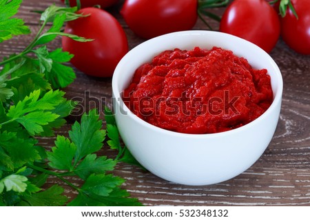 tomato sauce in a white bowl on wooden background