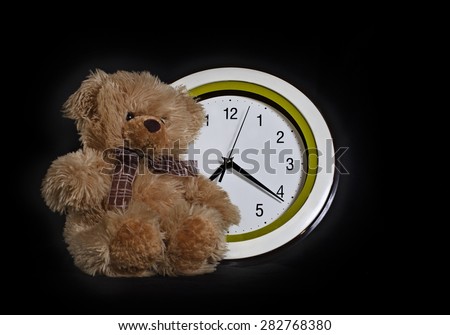 the bear cub Ã¢?? a toy sits in front of the round dial. A photo on a black background