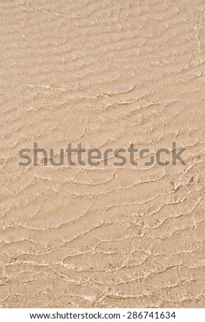 Shallow clean water flowing over sand