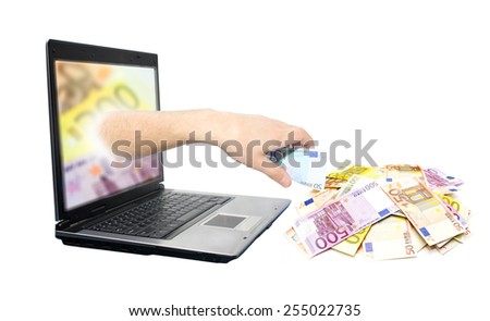 Hand with euro banknotes comes from the laptop screen. Online business concept