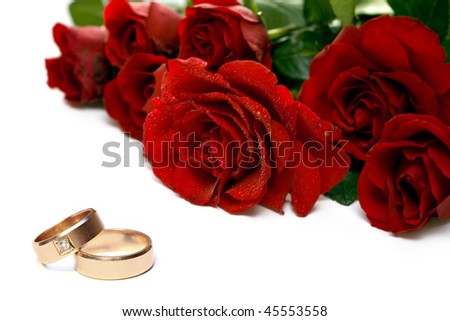 stock photo Red roses and wedding rings isolated on white