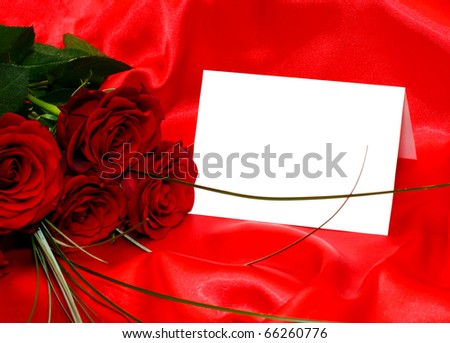 Red roses and invitation card on silk backgroundc
