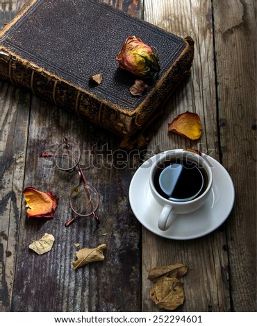 Old book , glasses,dried flower ,and leaves on a wooden table