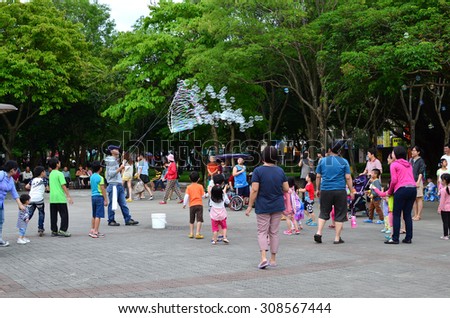 New Taipei City, Taiwan-26 April 2015: A man blowing soap bubbles to attract people in the park.