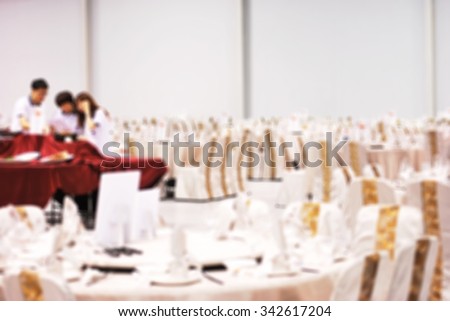 De focused/ Blurred image of  students of food & beverage management school preparing table and menu in restaurant hall.
