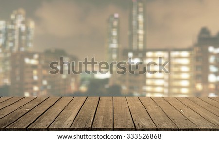 Wood floor in light yellow brown color tone with blurred abstract background of Hong Kong city night lights rooftop view with bokeh lights: Wooden tabletop with blur background of urban cityscape
