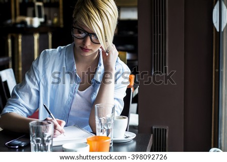 Business woman writing in a cafe