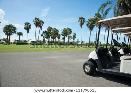 Golf carts on side of golf course.
