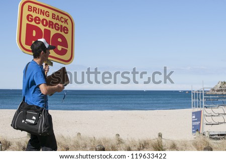 TAURANGA, NEW ZEALAND - NOVEMBER 4: A yung man carries the placard for a cause he is passionate about in Tauranga, New Zealand, November 4, 2012. Obtaining petition signatures is a common activity.
