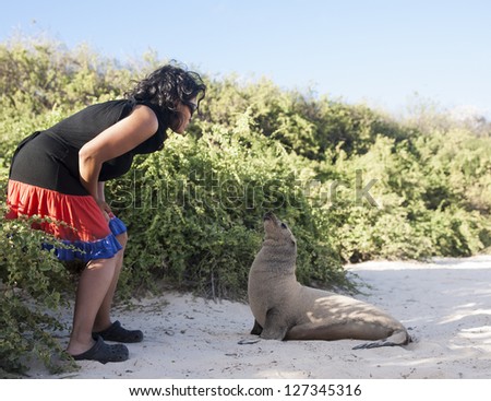Woman and  sea lion approach each other.