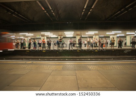LONDON, ENGLAND - JULY 16: People waiting on the other side of the London underground on July 16, 2013. The underground is a busy transportation system shifting over one thousand million each year.