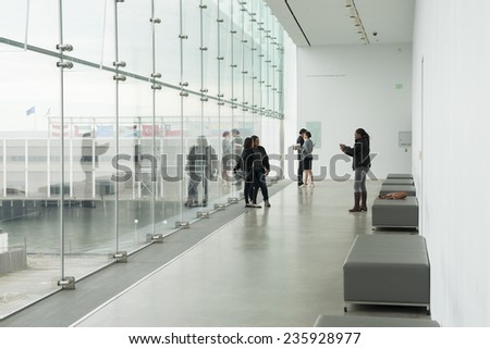 BOSTON, USA - OCTOBER 14; four young women taking photos and selfies in a hallway with Boston city background on October 14, 2014 in Boston USA . The girls are   in Institute of Contemporary Art.