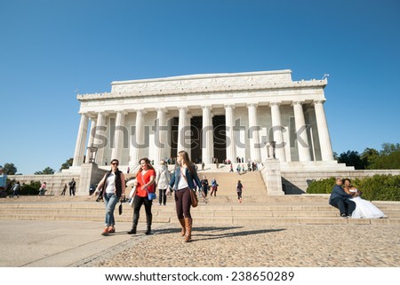 WASHINGTON DC, USA; OCTOBER 26; Tourists at the classical Greek temple style Lincoln Memorial marble steps and columns while a couple pose for wedding photographs October 2014 in Washington DC, USA