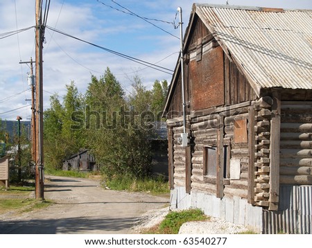 Old log building on dusty street, Dawson City, Yukon Territory, Canada.