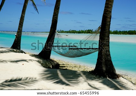 Palms and hammock at waters edge, Aitutaki, Cook Islands.