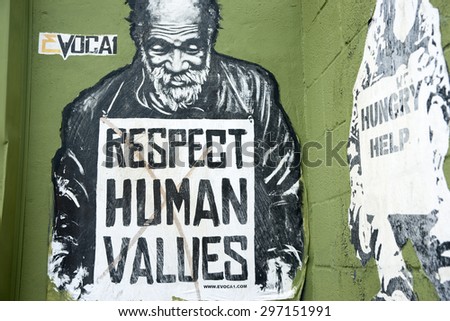 MIAMI, FLORIDA, USA - JUNE 28; Respect human values street art  image of destitute man with sign pleading for respect for the needy on June 28, 2012 in Wynwood, Miami., USA