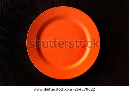 Empty Plate - Orange round empty plate on wooden background.