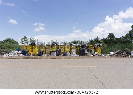 A public rubbish dump site at side of the road.